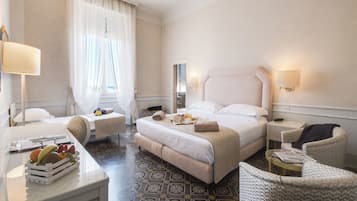 Ein Hotelzimmer mit Bett, Nachttischen, Schreibtisch, Stuhl und Essbereich.