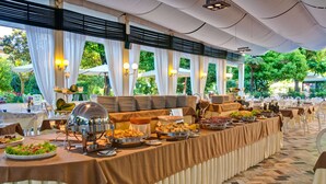 A buffet setup with various food items and a large serving area. - Grand Hotel Royal (Viareggio)