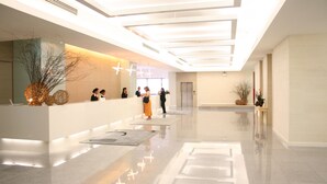 A modern hotel lobby with a reception desk, a large mirror, and a clean, polished floor. - Baiyoke Suite Hotel (Bangkok)