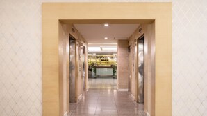 A hallway with elevators and a reception area. - Baiyoke Suite Hotel (Bangkok)