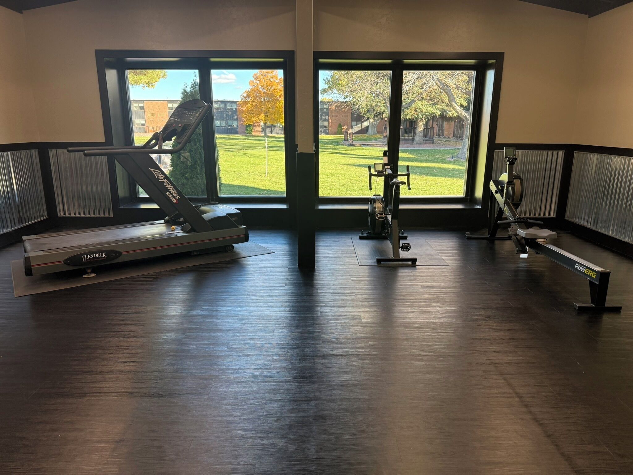 A gym with a treadmill, weight bench, and exercise equipment.