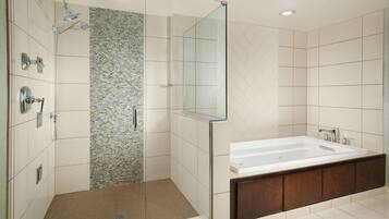 A modern bathroom with a walk-in shower, a large bathtub, and a vanity with a mirror.