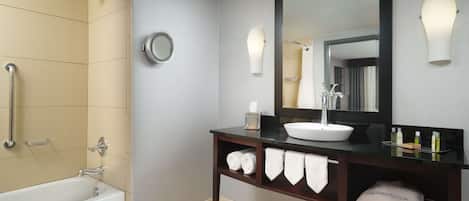 Un baño moderno con una bañera, un tocador con un espejo grande y un perchero para toallas.