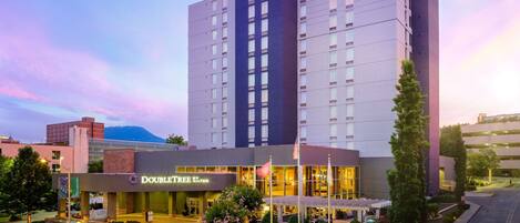 A DoubleTree by Hilton hotel with a modern design, a well-lit entrance, and a landscaped front yard.