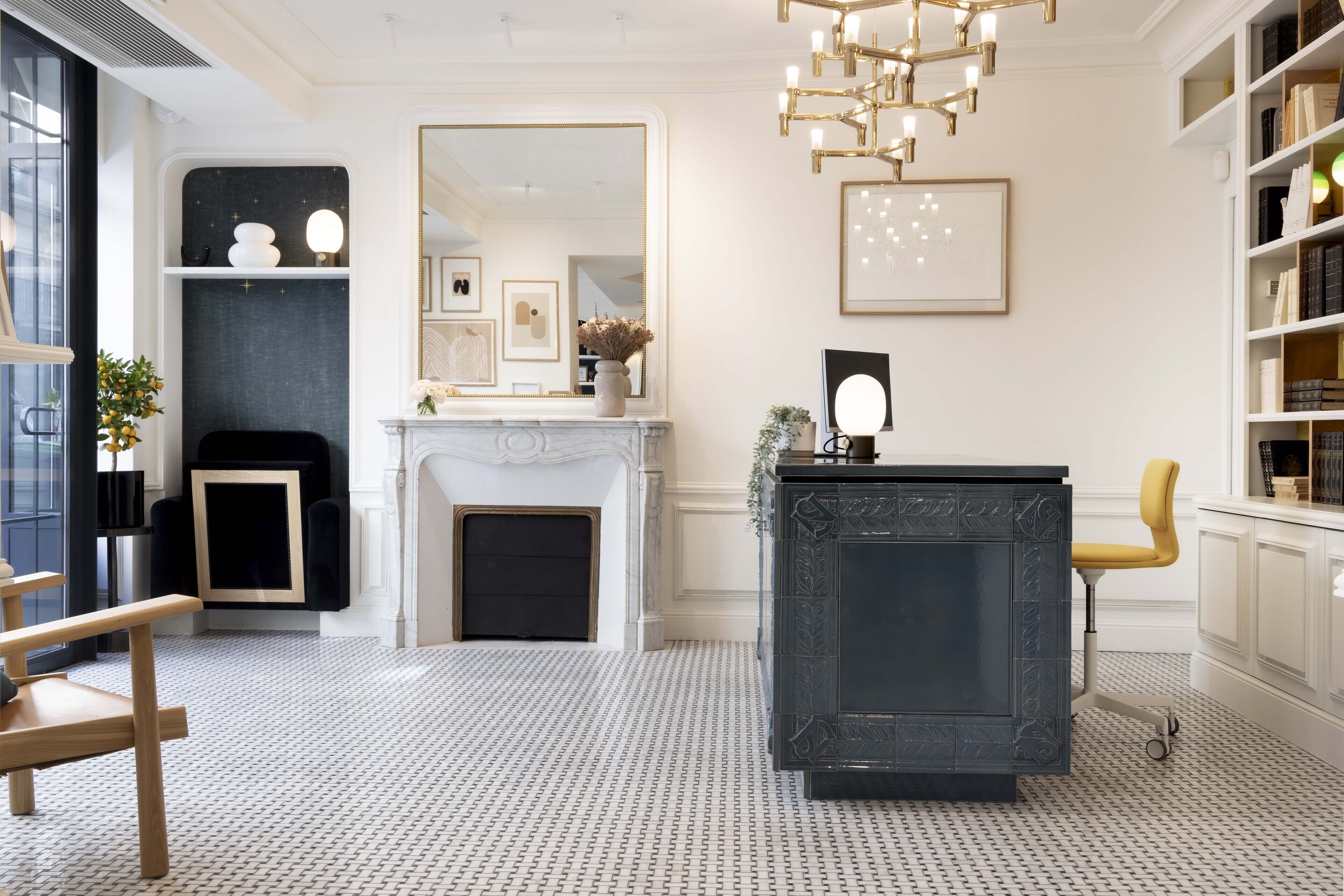 A modern interior with a fireplace, a black marble desk, and a yellow chair.