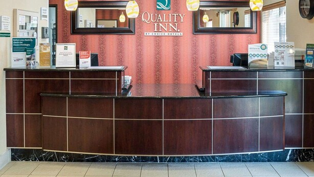 A reception desk with a sign reading "Quality Inn By Choice Hotels". - Quality Inn Brooklyn Center (Brooklyn Center)