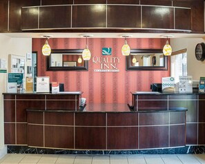 Una mesa de recepción con un cartel que dice 'Quality Inn By Choice Hotels'.