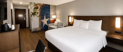 A hotel room with a large bed, a desk with a telephone, a chair, and a wall with a star decoration.