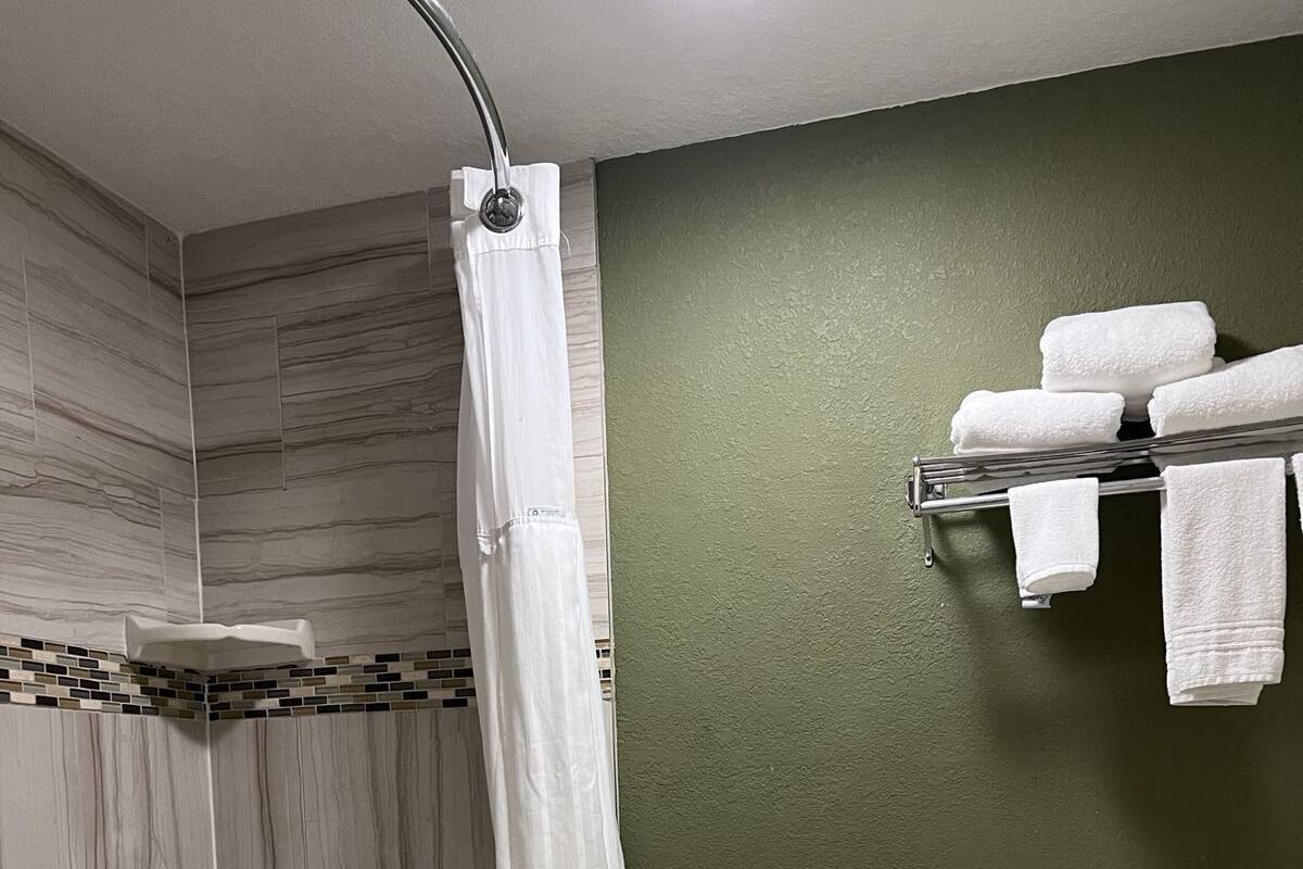 Un baño con bañera, inodoro y cortina de ducha.