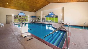An indoor swimming pool with clear blue water, surrounded by white lounge chairs and a wooden ceiling. - Country Inn & Suites by Radisson, Freeport, IL (Freeport)