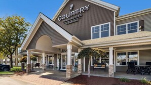 A Country Inn & Suites by Radisson with a covered patio area, outdoor seating, and a welcoming entrance. - Country Inn & Suites by Radisson, Freeport, IL (Freeport)
