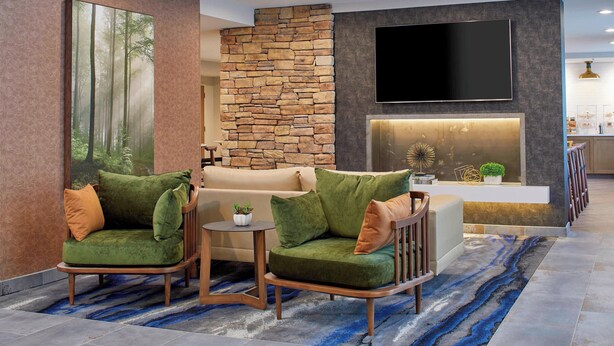 Ein modernes Wohnzimmer mit Steinwand, Flachbildfernseher, Sofa und Couchtisch.