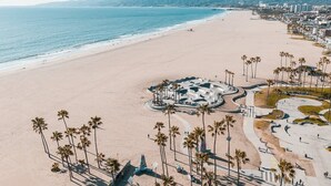 A beach with a circular plaza and palm trees. - Hotel MDR Marina del Rey - a DoubleTree by Hilton (Marina del Rey)