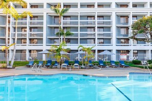 A hotel with a swimming pool, multiple balconies, and lounge chairs. - Hotel MDR Marina del Rey - a DoubleTree by Hilton (Marina del Rey)