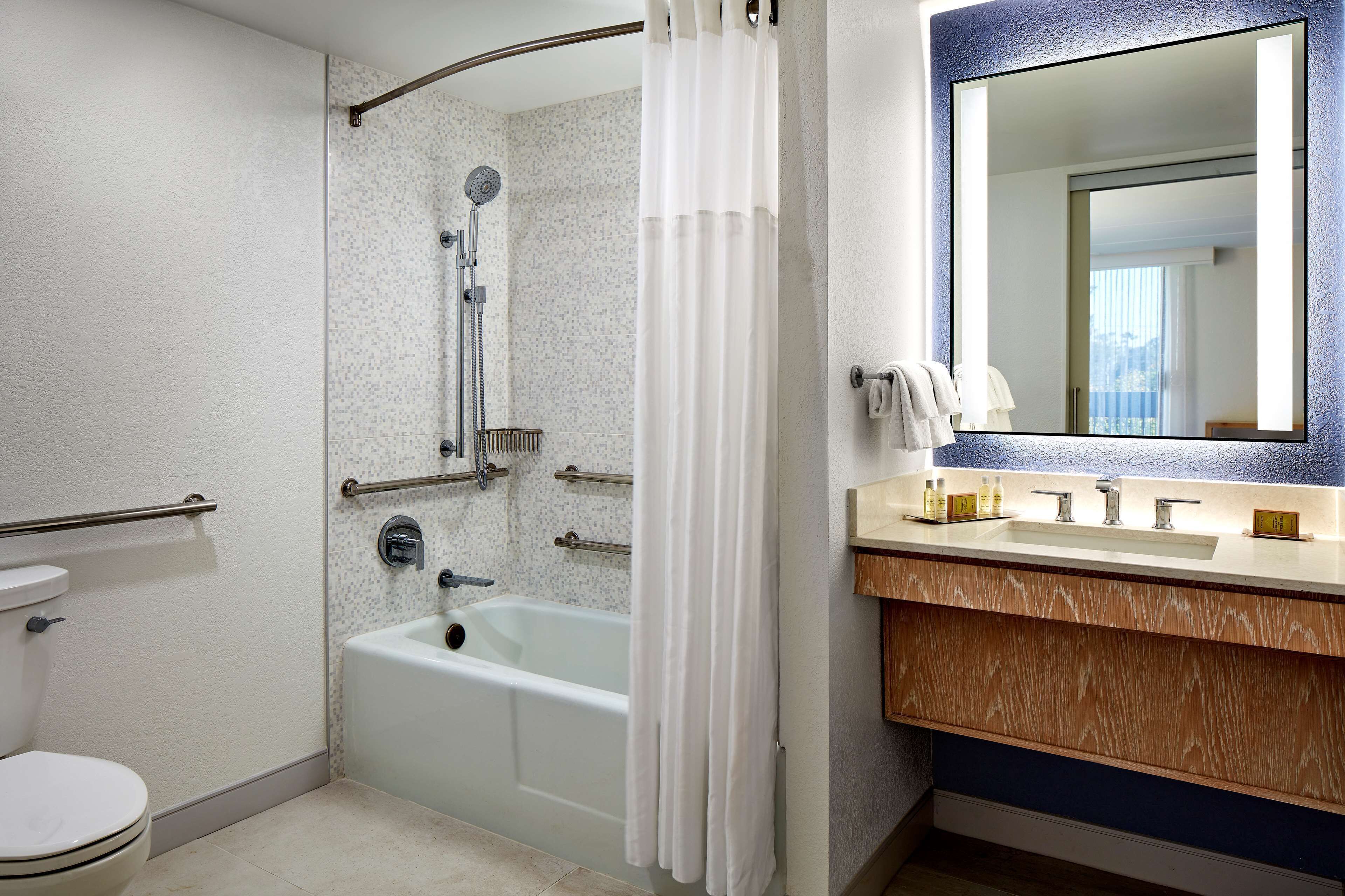 A bathroom with a shower, toilet, and sink.
