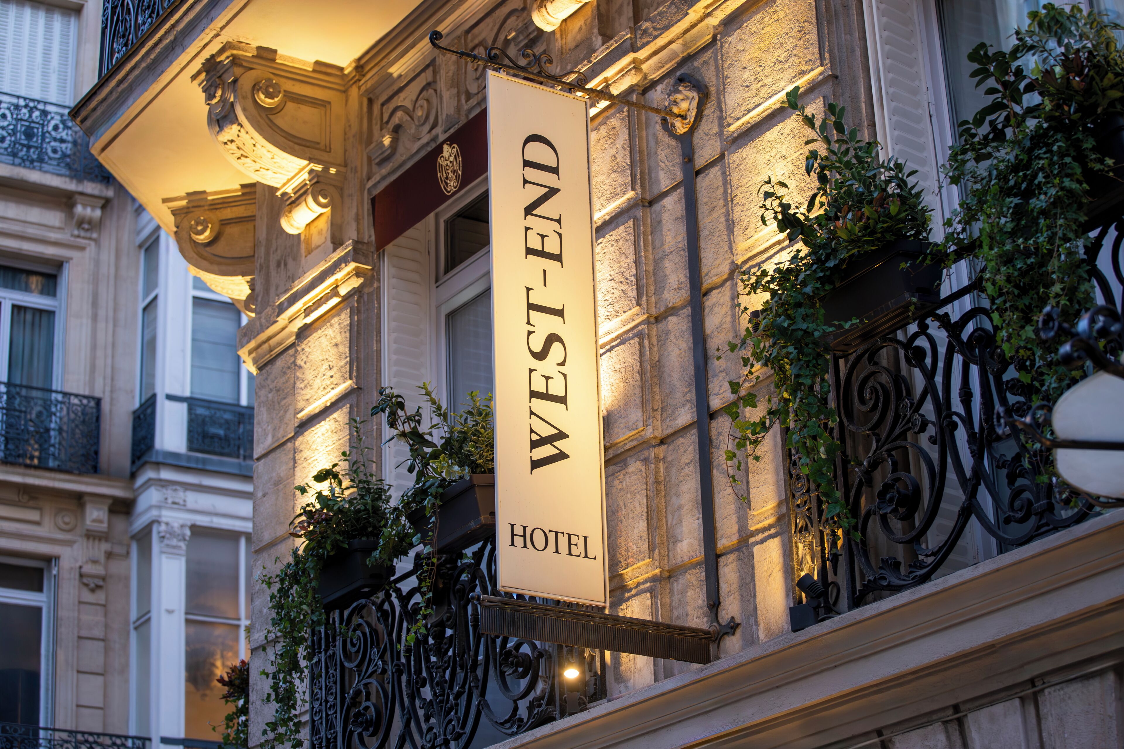 A hotel sign with the name "WEST-END HOTEL" mounted on a building facade.