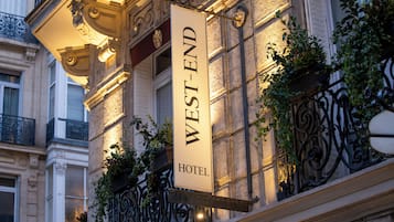 A hotel sign with the name "WEST-END HOTEL" mounted on a building facade.