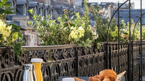 Una mesa con alimentos para el desayuno y vista a la Torre Eiffel.