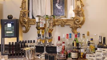 Zona de bar con una variedad de botellas de licor, vasos y un espejo decorativo.