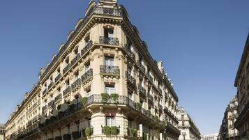 Un edificio de varios pisos con balcones ornamentados y un estilo arquitectónico clásico.