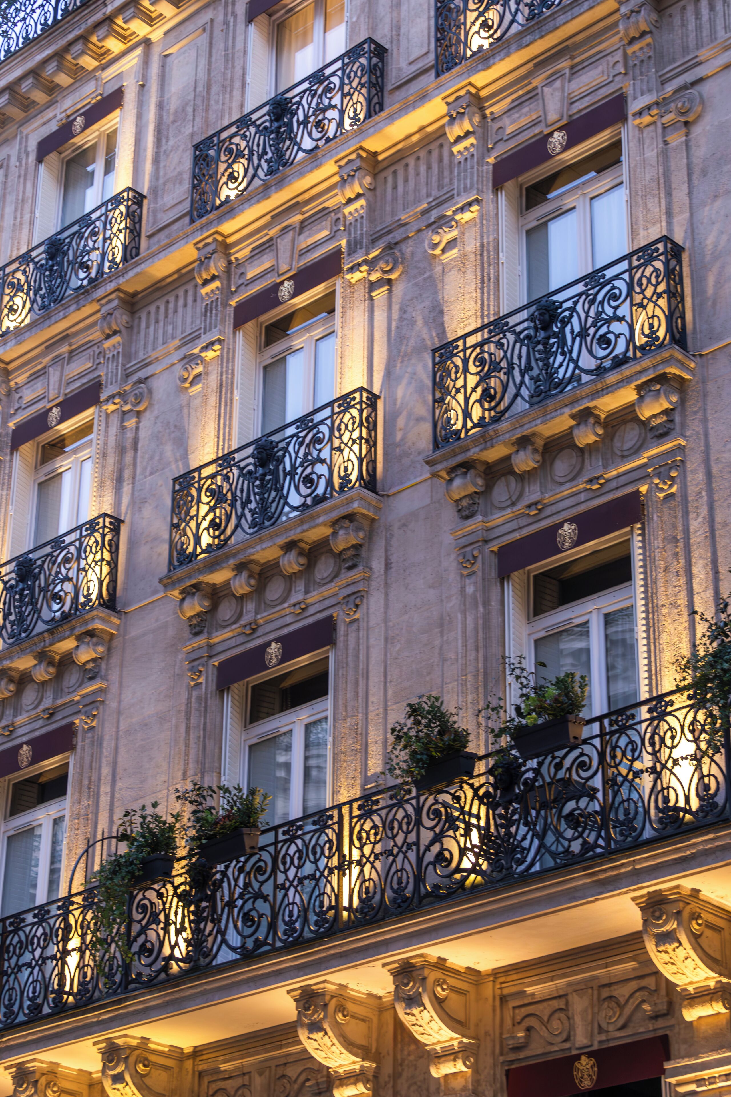 A multi-story building with ornate iron balconies and decorative moldings.