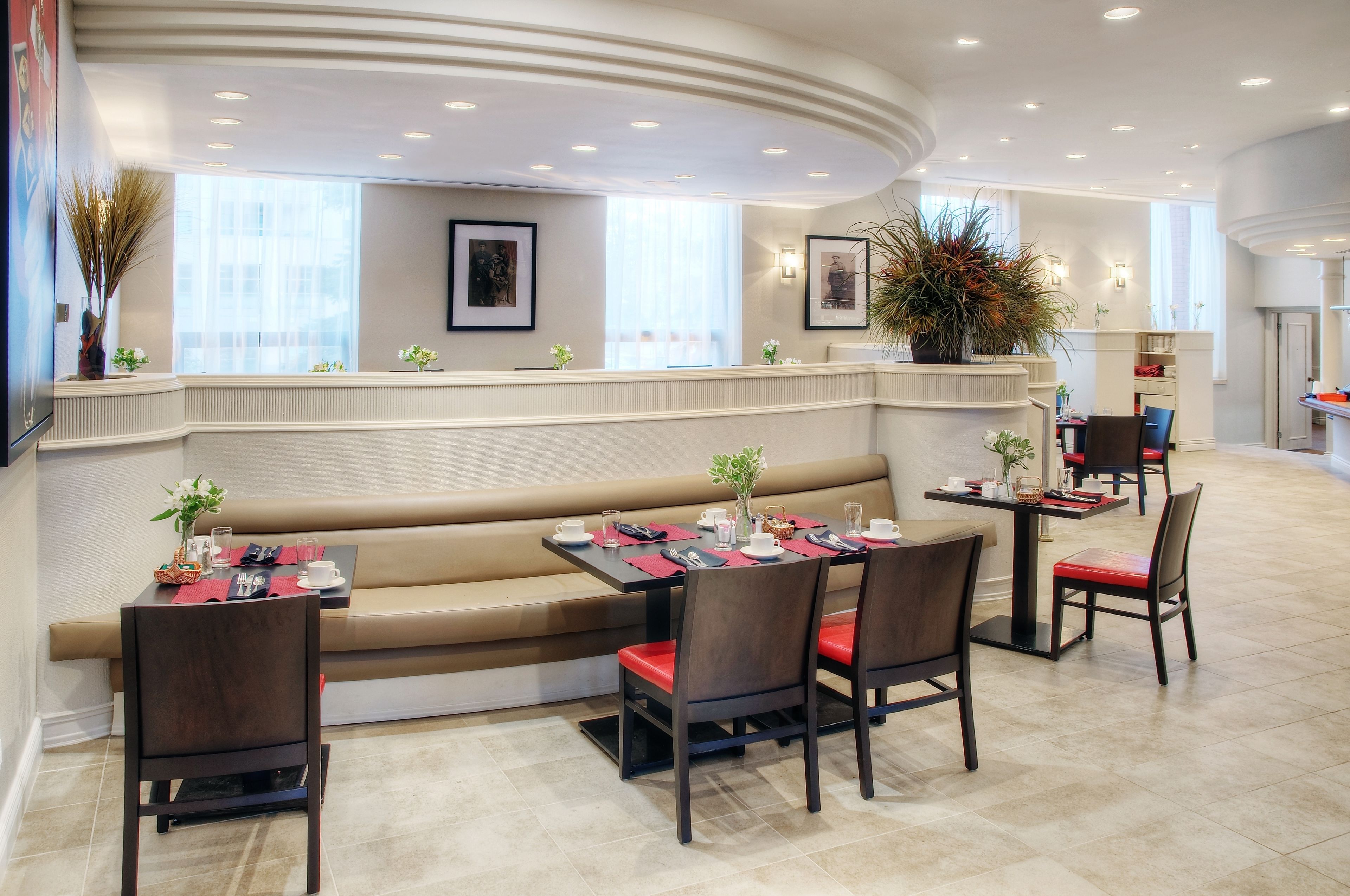 A restaurant with a curved counter, cushioned seating, and a view of the city.