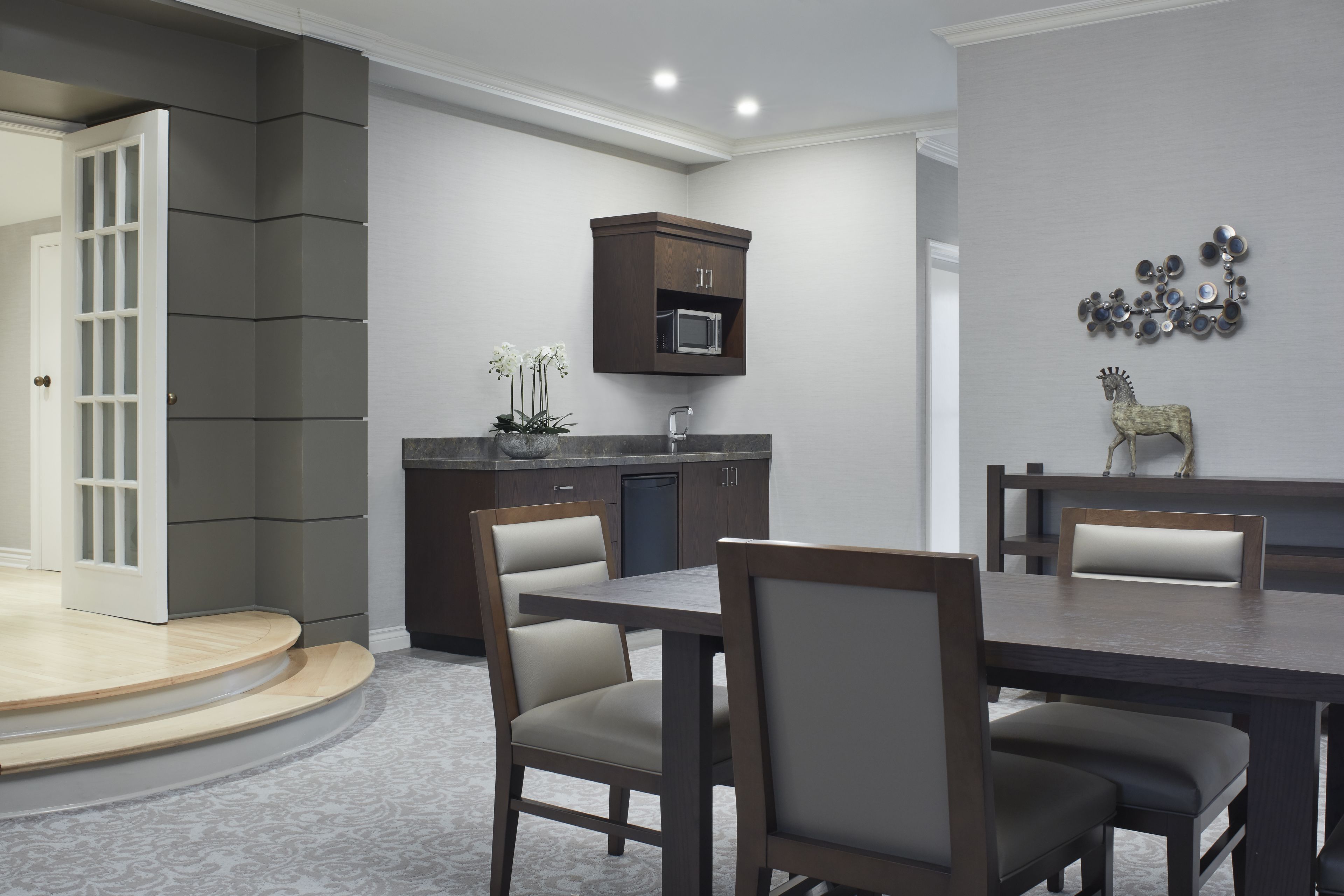 A modern kitchen with dark cabinetry, a microwave, and a decorative wall piece.