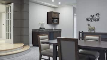 A modern kitchen with dark cabinetry, a microwave, and a decorative wall piece.