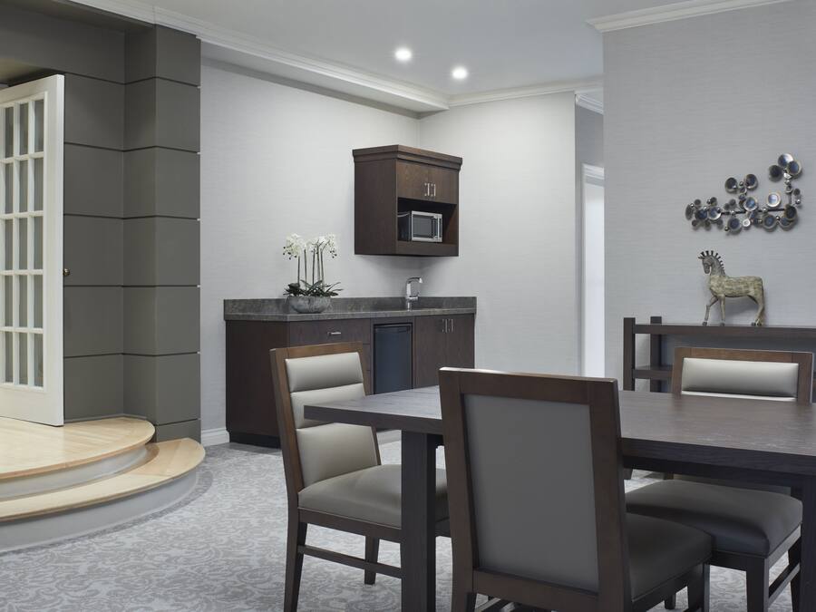 A modern kitchen with dark cabinetry, a microwave, and a decorative wall piece.