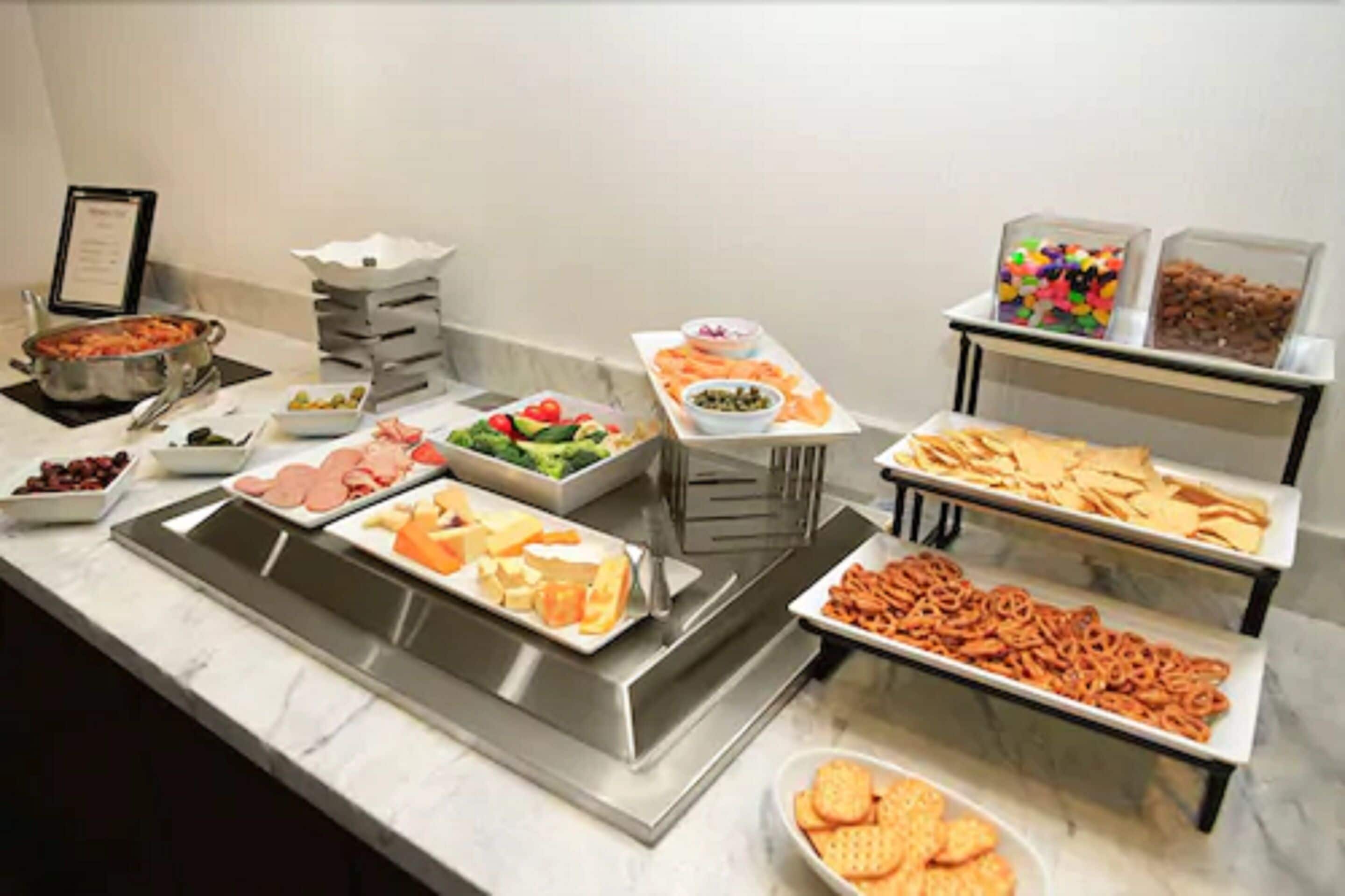 A buffet with various food items including fruits, cheeses, and snacks.