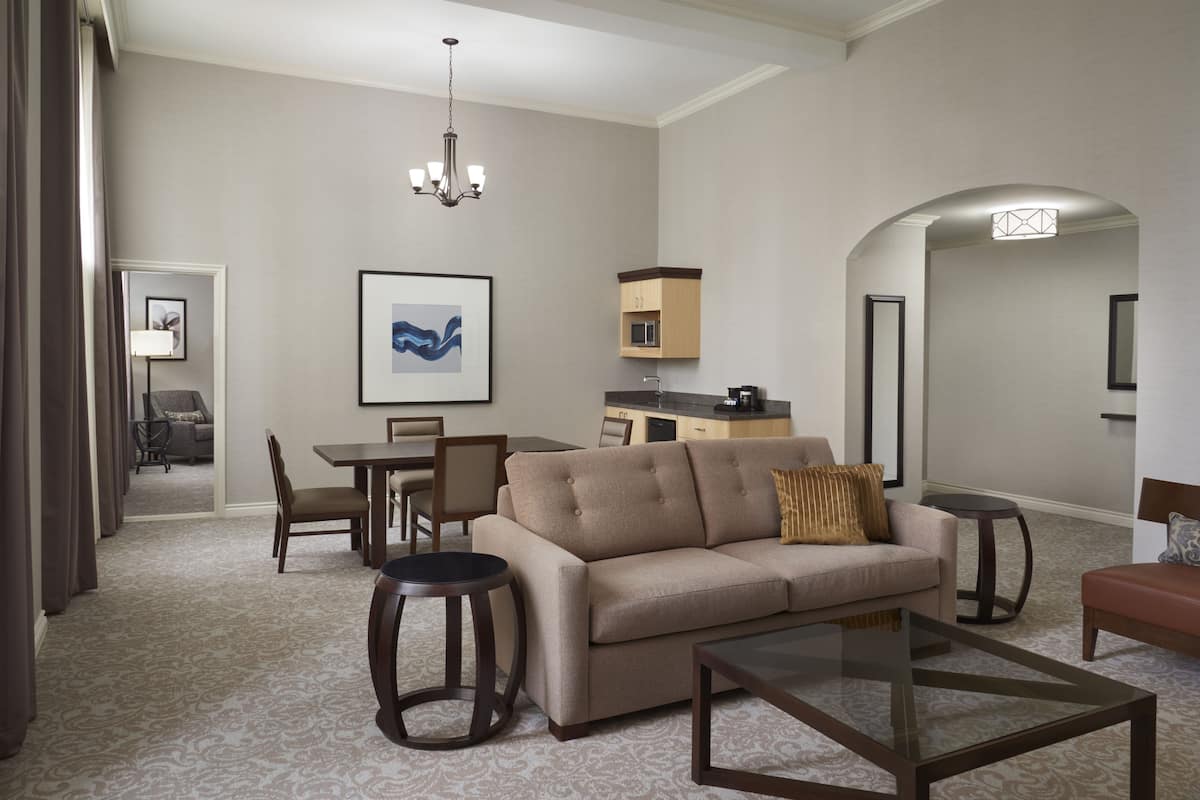 A modern living room with a sofa, coffee table, and dining area.