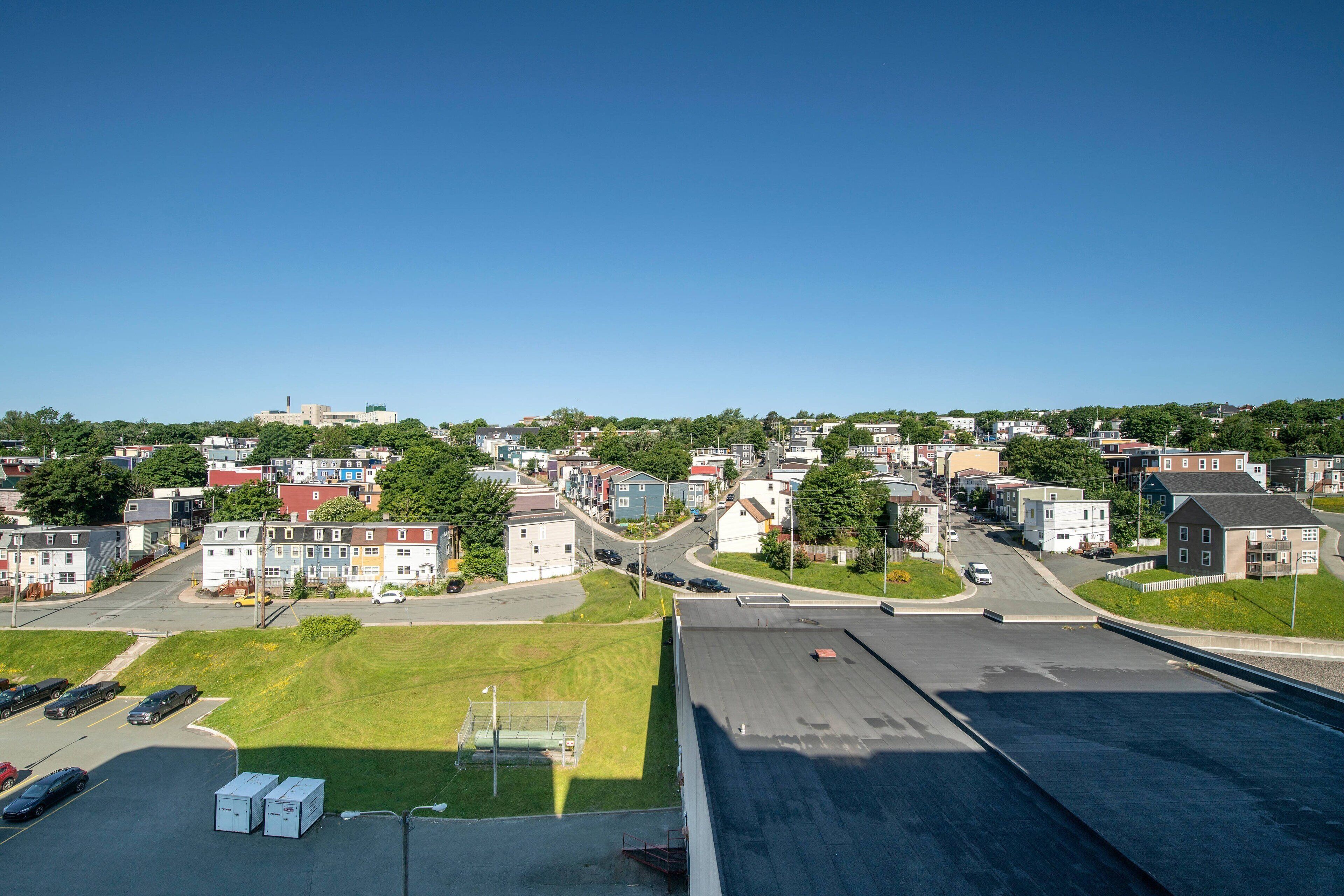 A residential area with houses, a road, and a parking lot.