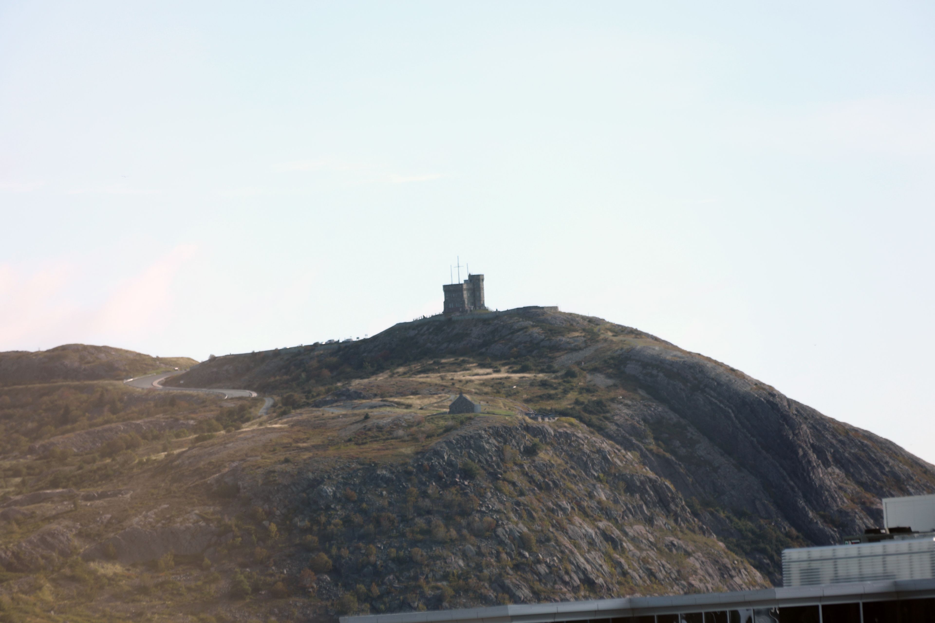 A mountainous landscape with a small building on top.