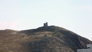 A mountainous landscape with a small building on top.