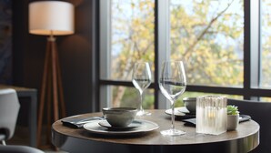 A dining table with a bowl, two wine glasses, and a candle holder. - Delta Hotels by Marriott Sherbrooke Conference Centre (Sherbrooke)