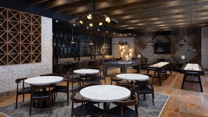 Ein modernes Restaurant mit runden Tischen und Stühlen, einer Ziegelwand und Holzböden.