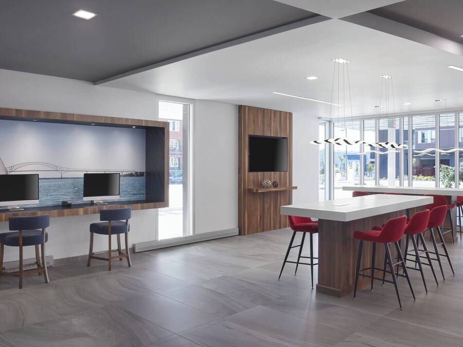 A modern kitchen with a large island, bar stools, and a TV mounted on the wall.