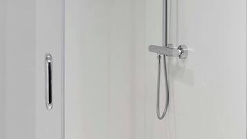A modern shower enclosure with a handheld showerhead and a fixed showerhead.