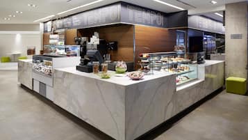 A modern food counter with a marble countertop and glass display cases.