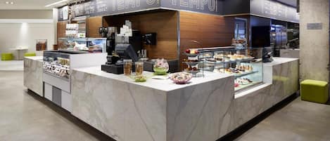 A modern food counter with a marble countertop and glass display cases.