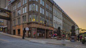 Un edificio en esquina con ventanas grandes, una estatua y un cartel de la Universidad NSCAD.