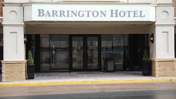 L’extérieur de l’hôtel Barrington se caractérise par une entrée bien visible, une façade en pierre et une enseigne au-dessus des portes.