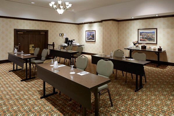 A conference room with a large table, chairs, and a coffee station.