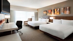 A hotel room with two beds, a desk, a TV, and artwork on the wall. - Delta Hotels by Marriott Saint John (Saint John)