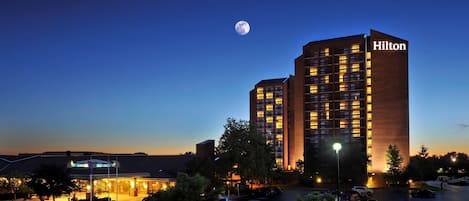 Ett Hilton-hotell med en modern design, som har flera våningar och en tydlig skylt med texten ”Hilton”.