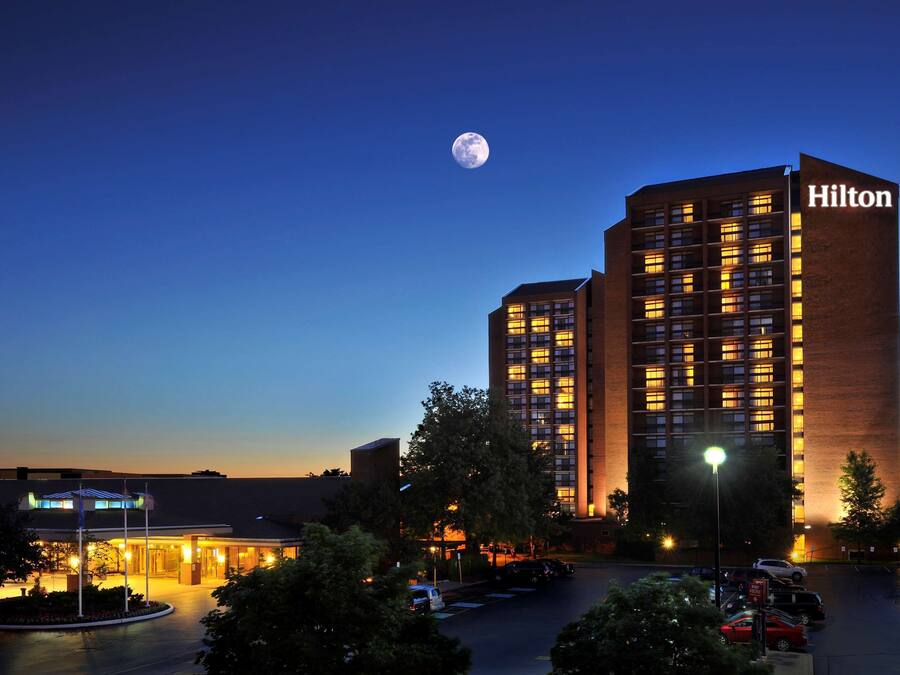 A Hilton hotel with a modern design, featuring multiple floors and a prominent "Hilton" sign.