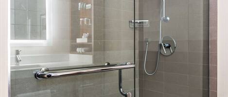 A modern bathroom with a glass shower enclosure, a glass door, and a visible towel rack.