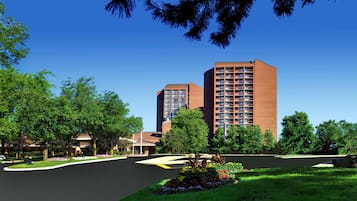 A modern building with a brick facade, surrounded by lush greenery and a well-maintained lawn.