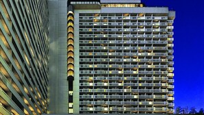 A hotel with a modern design, featuring a prominent entrance and a large building with multiple balconies.