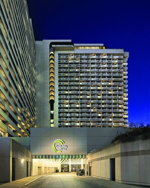 A hotel with a modern design, featuring a prominent entrance and a large building with multiple balconies.